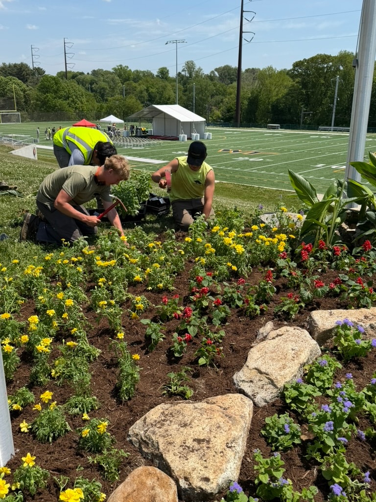 Crew installing a custom flower planting for a graduation ceremony in Media, PA